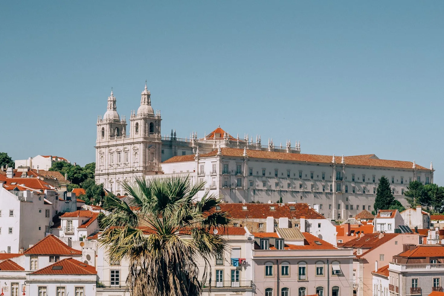 Family riding a tuk-tuk through a Lisbon square