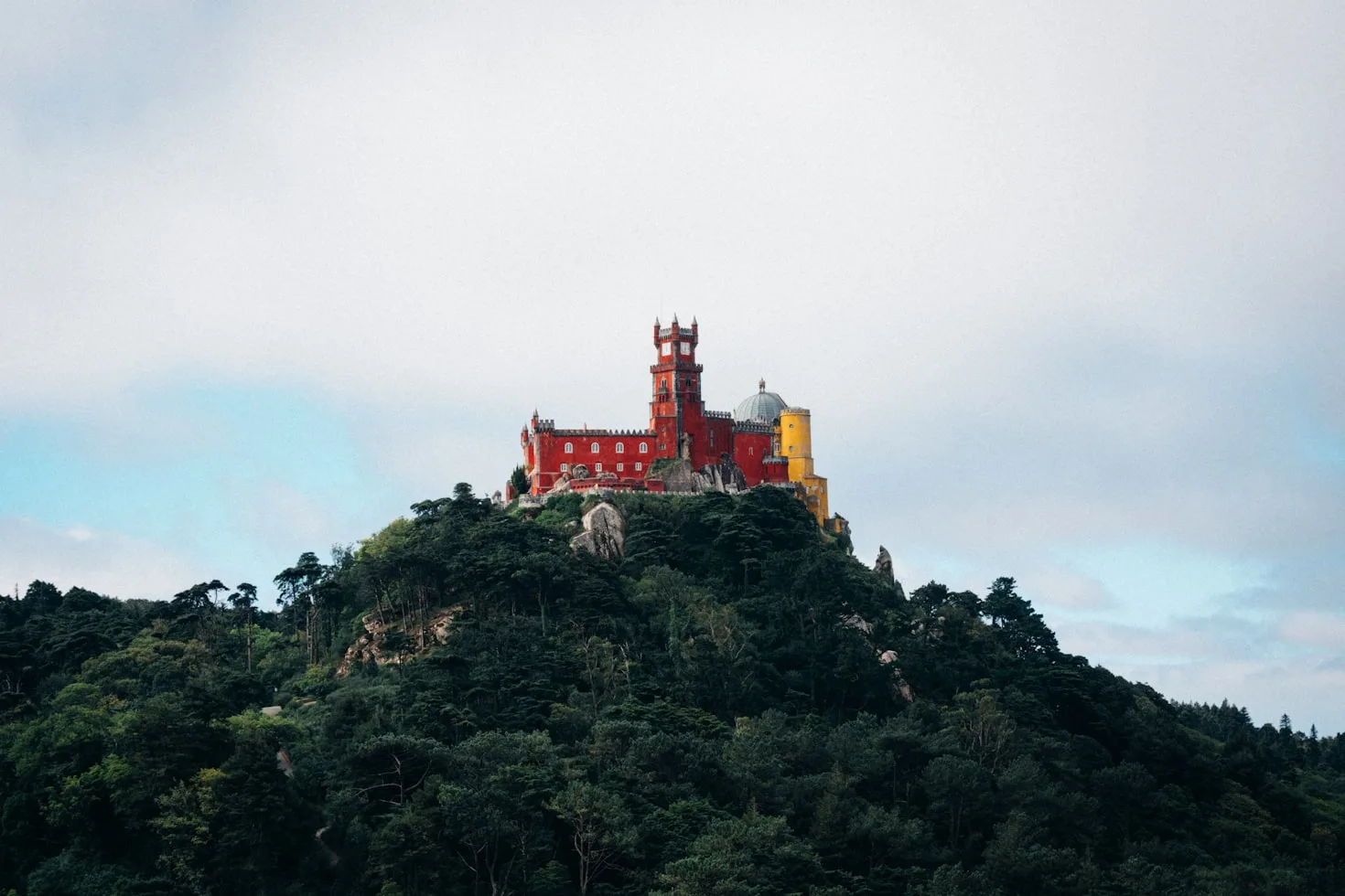 Pena Palace in Sintra rising above the forest in morning mist